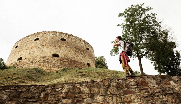 Foto gratuito uomo di angolo basso che prende le foto del castello