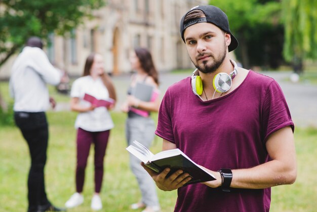 Uomo di barba che tiene libro di testo in piedi