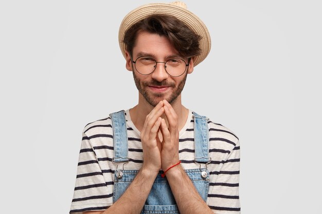 Uomo di Brunet che indossa un cappello e tute di jeans