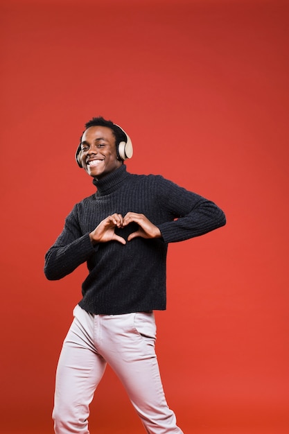 Uomo di colore che posa con le cuffie