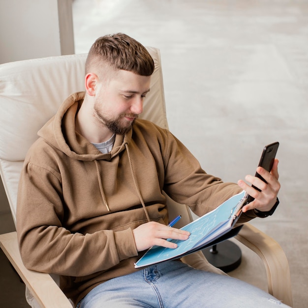 Uomo di colpo medio che tiene smartphone