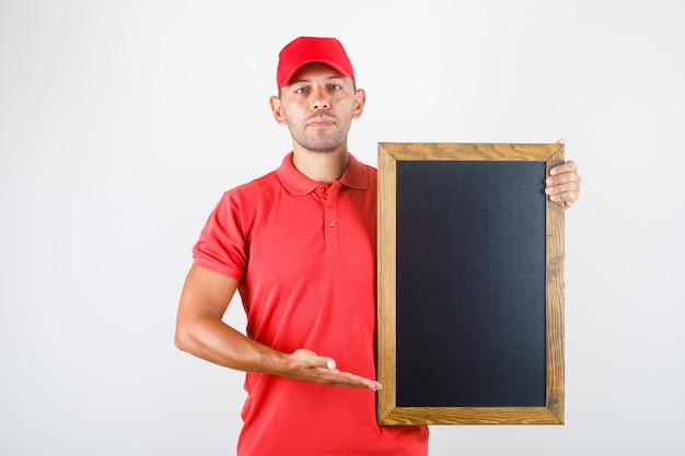 Uomo di consegna che tiene lavagna in vista frontale uniforme rossa.