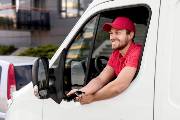 Uomo di consegna in auto con il cellulare