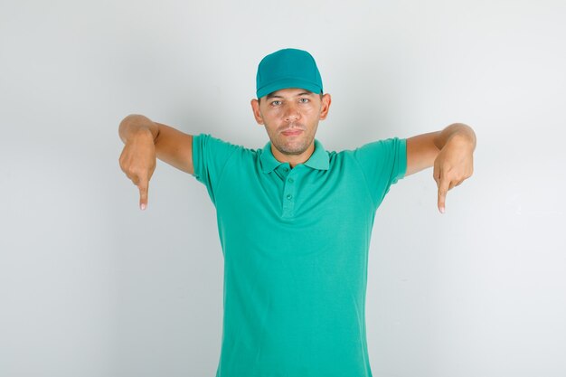 Uomo di consegna in maglietta verde e cappuccio rivolto verso il basso e guardando fiducioso
