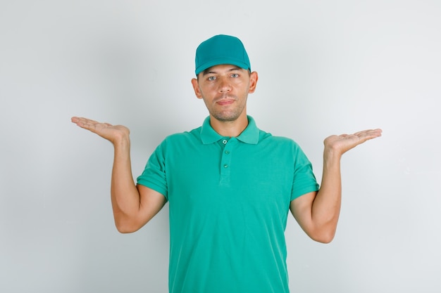 Uomo di consegna mantenendo le mani vuote in maglietta verde con cappuccio