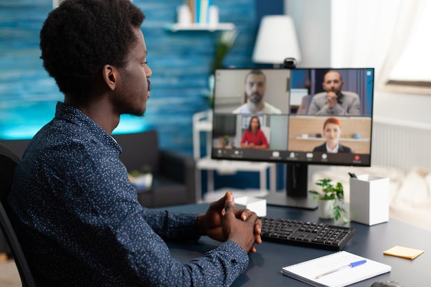 Uomo di etnia africana che utilizza la comunicazione via webcam per conferenze