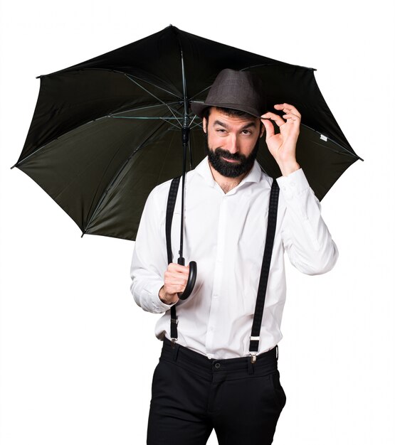 Uomo di Hipster con la barba che tiene un ombrello