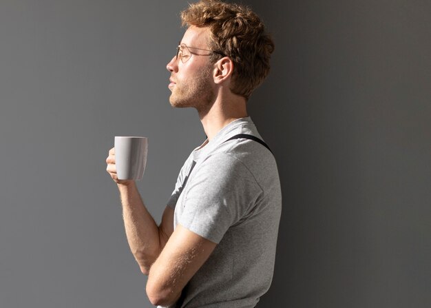 Uomo di lato che beve il suo caffè