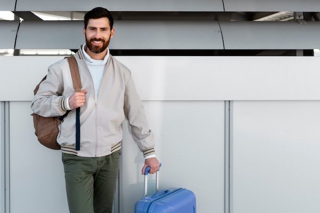 Uomo di media portata che viaggia con i bagagli.