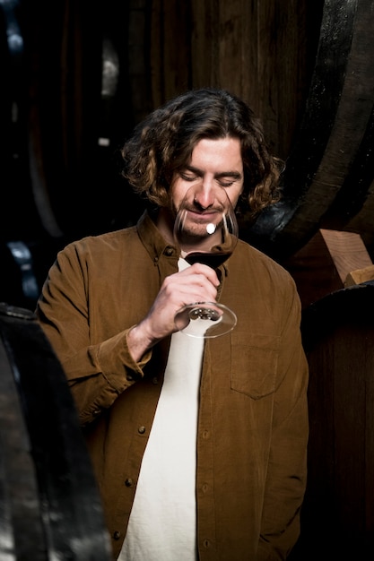 Uomo di medio calibro che assaggia il vino.