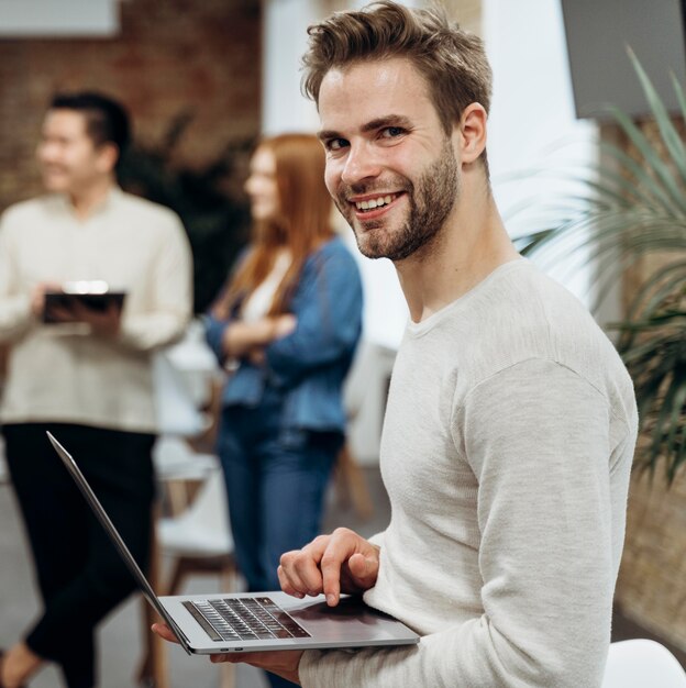 Uomo di smiley che lavora al computer portatile mentre levandosi in piedi