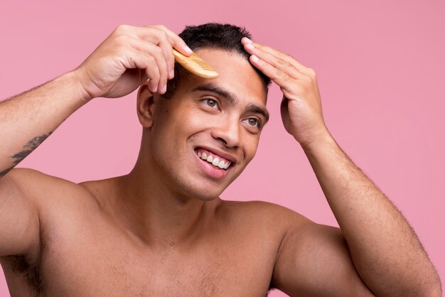 Uomo di smiley che pettina i suoi capelli