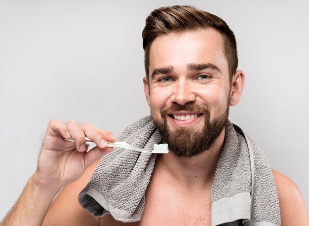 Uomo di smiley che tiene uno spazzolino da denti