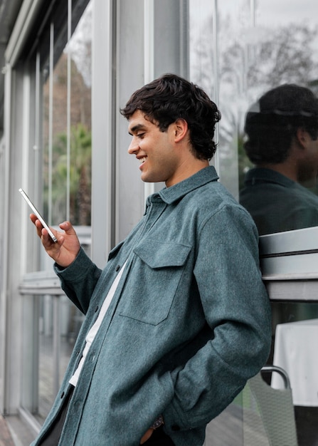 Uomo di smiley colpo medio con il telefono