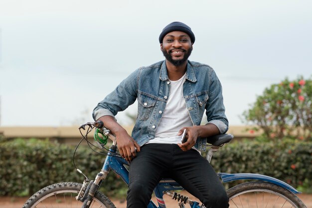 Uomo di smiley colpo medio con la bicicletta in natura