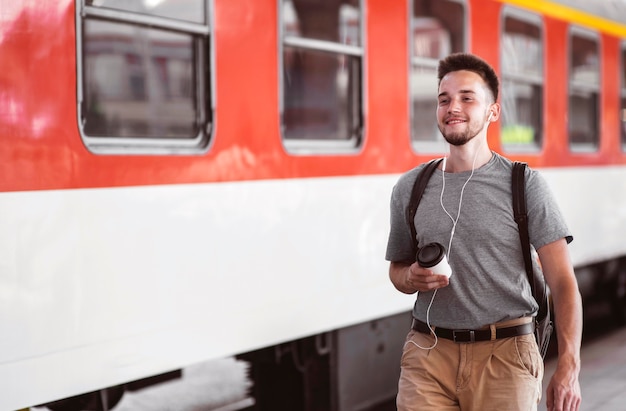 Uomo di smiley del colpo medio che indossa gli auricolari