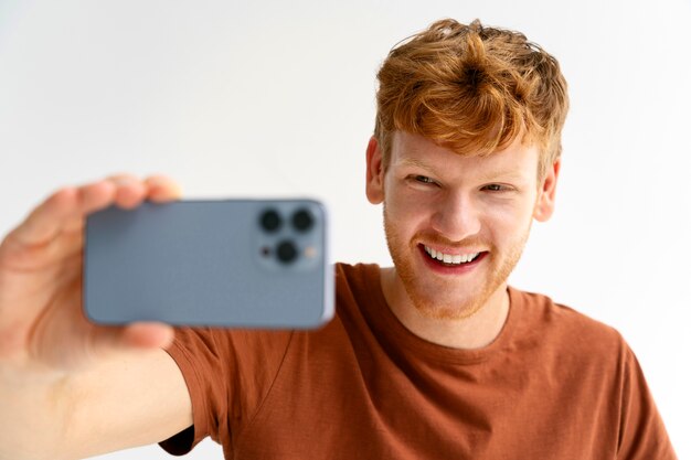 Uomo di smiley del colpo medio che prende selfie