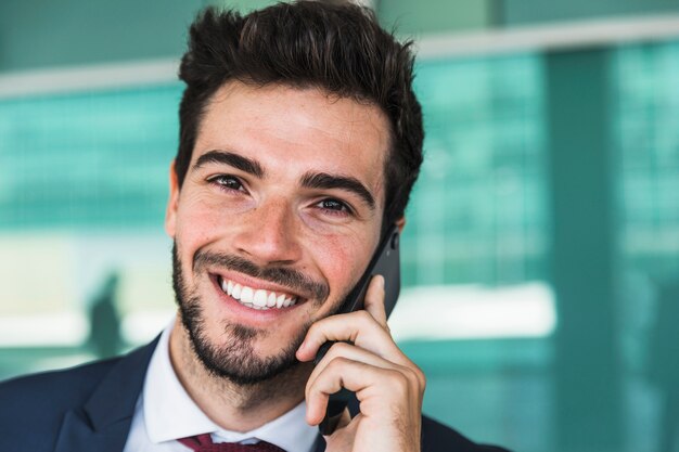 Uomo di smiley del primo piano che parla al telefono