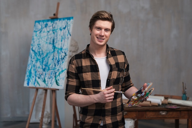 Uomo di smiley di vista frontale che mescola i colori differenti per la sua pittura