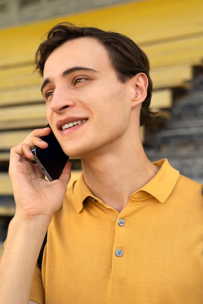 Uomo di smiley di vista laterale che parla sul telefono