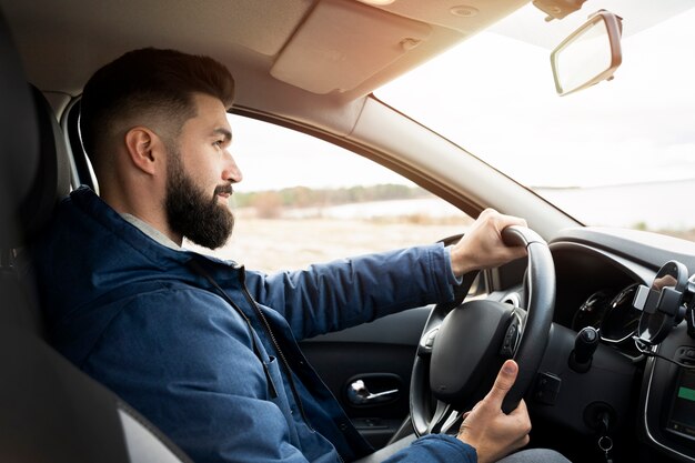 Uomo di tiro medio alla guida di un'auto