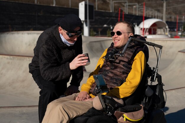 Uomo di tiro medio che aiuta un amico disabile