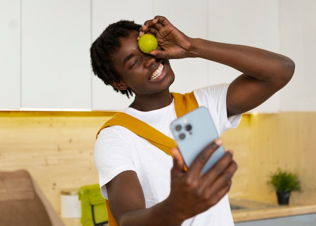 Uomo di tiro medio che cucina con lo smartphone