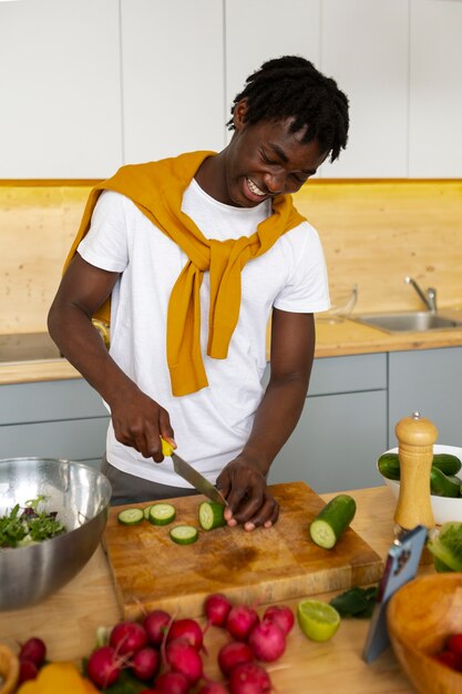 Uomo di tiro medio che cucina con lo smartphone