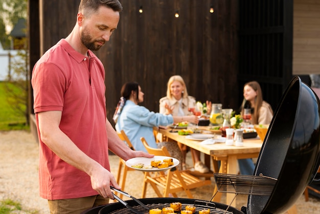 Uomo di tiro medio che fa barbecue