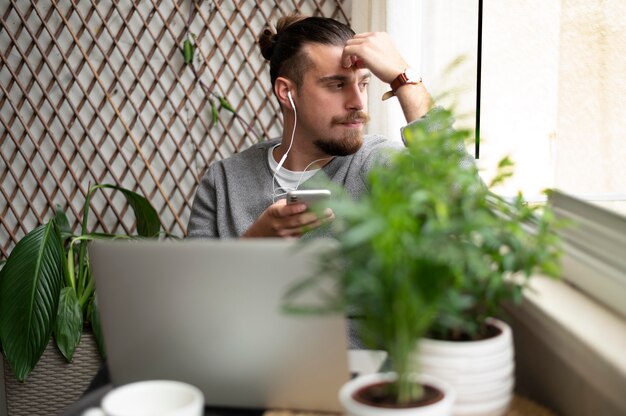 Uomo di tiro medio che lavora con gli auricolari