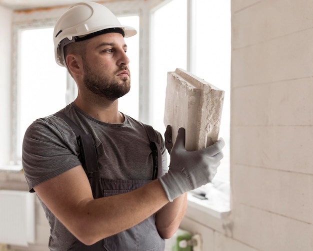 Uomo di tiro medio che lavora con il casco