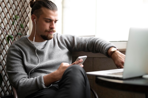 Uomo di tiro medio che lavora con il telefono