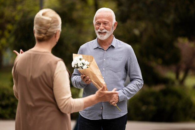 Uomo di tiro medio che offre fiori