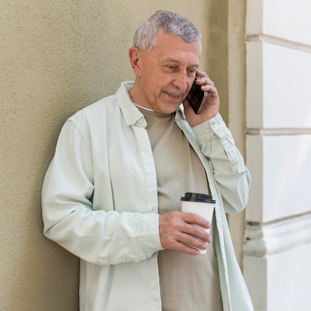 Uomo di tiro medio che parla al telefono