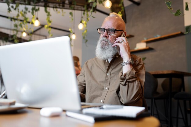 Uomo di tiro medio che parla al telefono