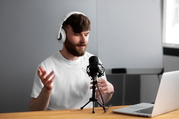 Uomo di tiro medio che registra podcast al chiuso