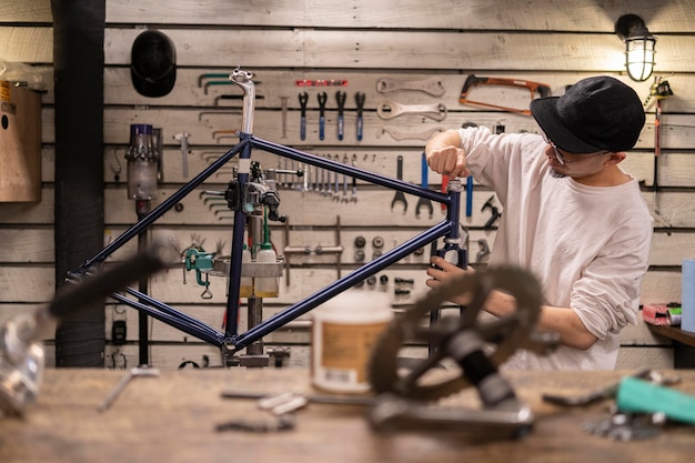 Uomo di tiro medio che ripara bici