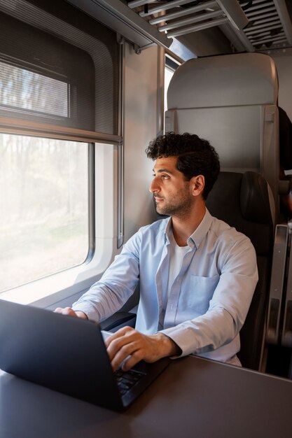 Uomo di tiro medio che viaggia in treno