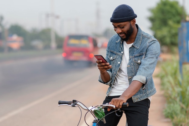 Uomo di tiro medio con bicicletta e telefono