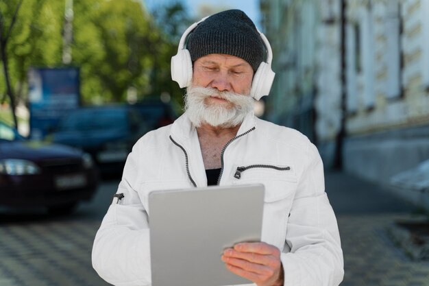 Uomo di tiro medio con cuffie e tablet