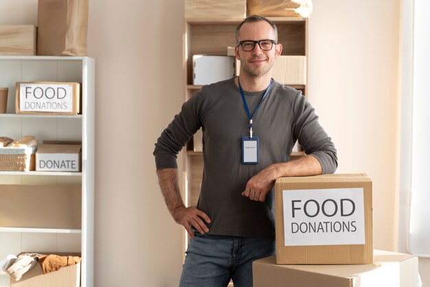 Uomo di tiro medio con donazioni di cibo