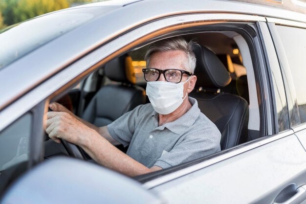 Uomo di tiro medio con maschera alla guida