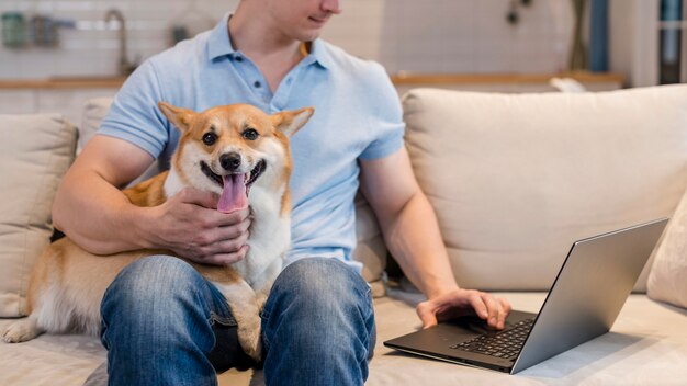 Uomo di vista frontale che lavora mentre si tiene il cane