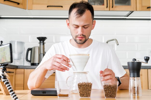 Uomo di vista frontale che produce caffè