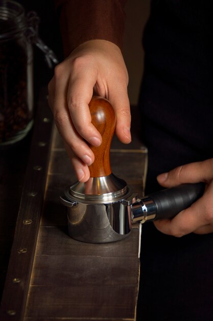 Uomo di vista frontale che produce caffè