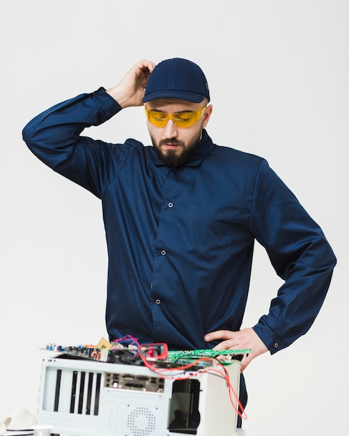 Uomo di vista frontale che ripara un computer