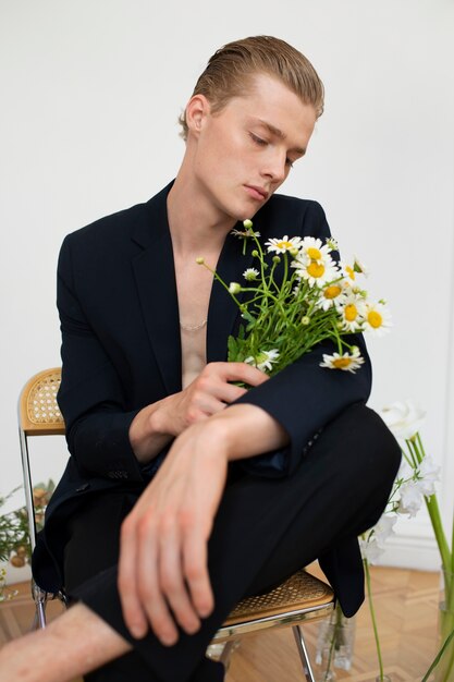 Uomo di vista frontale che si siede con i fiori