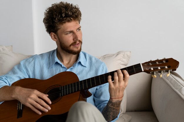 Uomo di vista frontale che suona la chitarra
