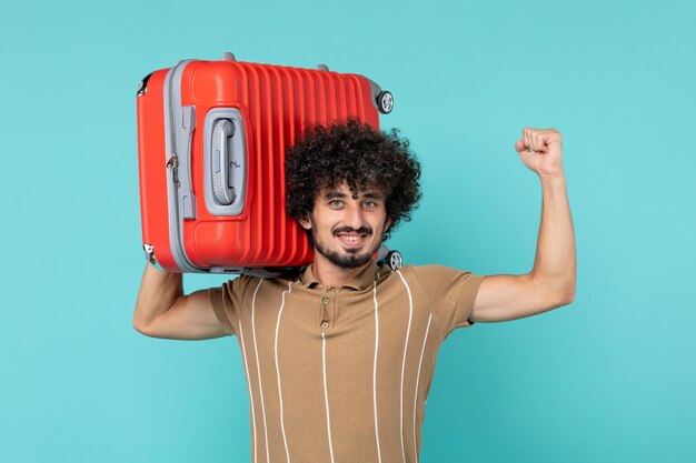 Uomo di vista frontale in vacanza che tiene la sua grande borsa su blue