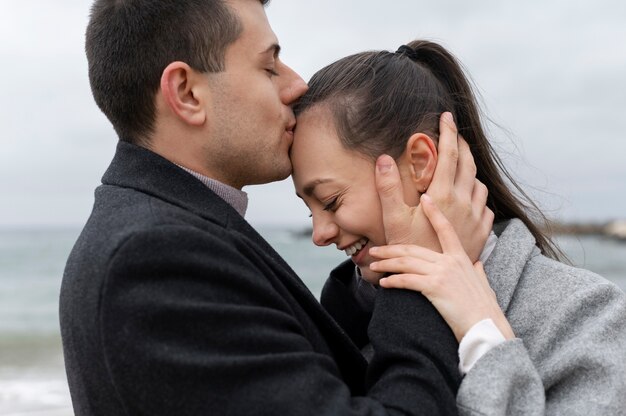 Uomo di vista laterale che bacia la fronte della donna